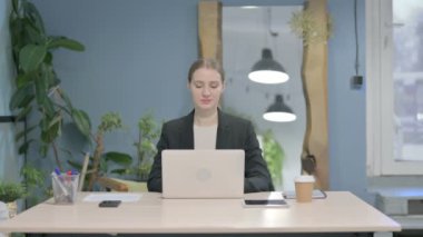 Young Businesswoman Typing on Laptop in Office