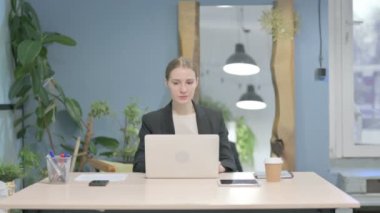 Young Businesswoman Leaving Office after Closing Laptop