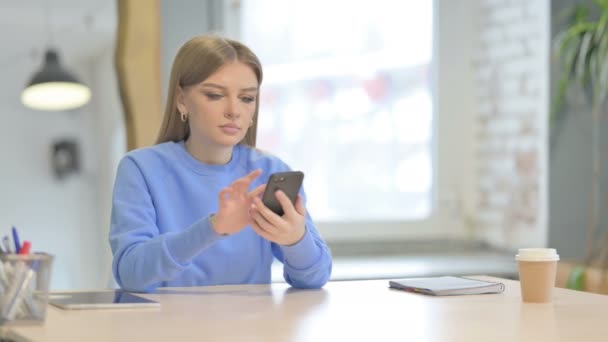 Νεαρή Γυναίκα Περιήγηση Στο Internet Στο Smartphone Στο Γραφείο — Αρχείο Βίντεο