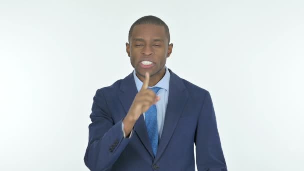 白い背景に沈黙を求めて唇に指で若いアフリカのビジネスマン — ストック動画