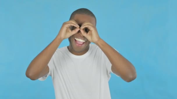 Excited Young African Man Searching Handmade Binocular Blue Background — Stock video