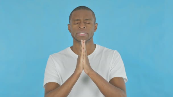 非洲年轻人在蓝色背景下向上帝祈祷 — 图库视频影像