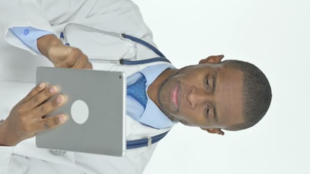 白い背景にデジタルタブレットを使用した若いアフリカ人医師の垂直ビデオ — ストック動画