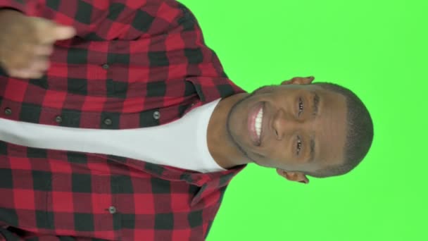 Vertical Video Pointing Young African Man Inviting Green Background — Stockvideo