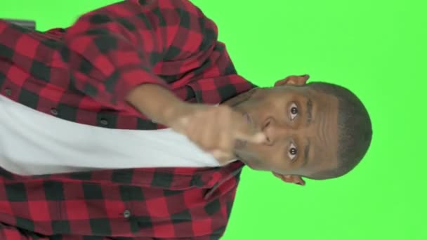 Вертикальне Відео Злий Молодий Африканський Чоловік Сперечається Зеленому Тлі — стокове відео