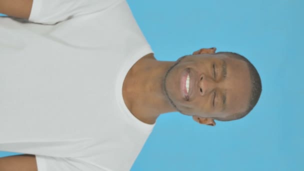 青の背景に若いアフリカ人男性による承認の垂直ビデオ — ストック動画