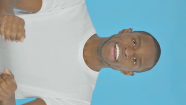 青の背景に成功した若いアフリカ人男性の垂直ビデオ — ストック動画