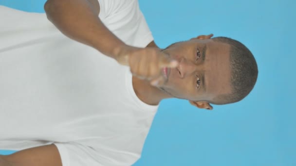 非洲青年男子在蓝色背景相机前指点的垂直视频 — 图库视频影像