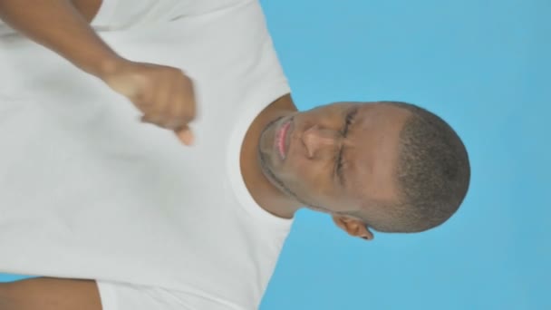 青の背景に若いアフリカ人男性を咳の垂直ビデオ — ストック動画