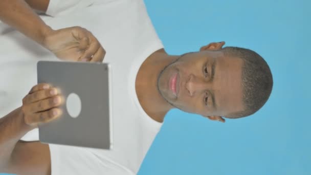 Vertical Video Young African Man Using Digital Tablet Blue Background — Stockvideo