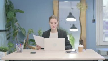 Young Businesswoman Working on Laptop and Documents