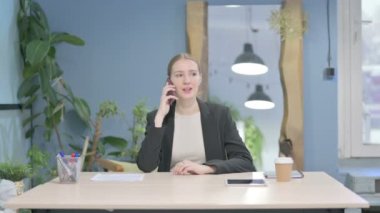 Young Businesswoman Talking on Phone in Office