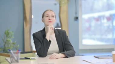 Pensive Young Businesswoman Thinking while Sitting at Work