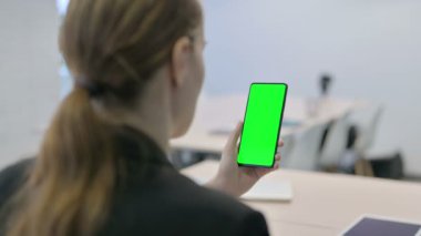 Young Businesswoman Using Smartphone with Green Screen