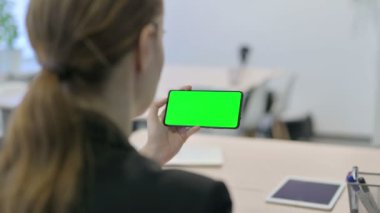 Young Businesswoman Holding Horizontal Smartphone with Green Screen