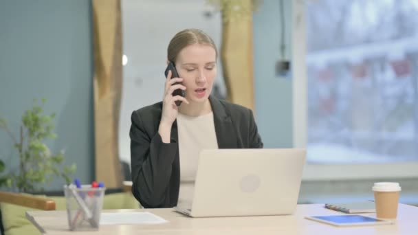 不満な若いビジネスマン女性は仕事でスマートフォンで怒って話す — ストック動画