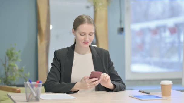 成功した若いビジネスマンの女性はスマートフォンで勝利を祝う — ストック動画