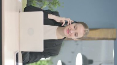 Vertical Video of Young Businesswoman Talking on Phone at Work