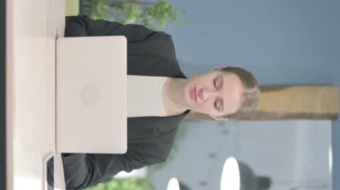 Vertical Video of Young Businesswoman Looking at Camera while using Laptop