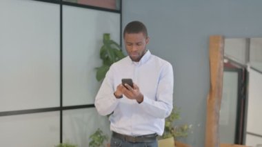 Shocked African American Man Reacting to Loss on Smartphone