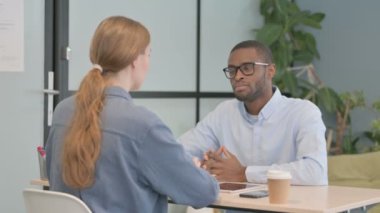 African American Man Talking with Woman in Office