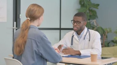 African American Doctor Talking with Patient in Clinic