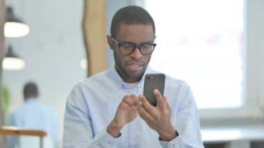 Portrait of African American Man with Loss on Smartphone