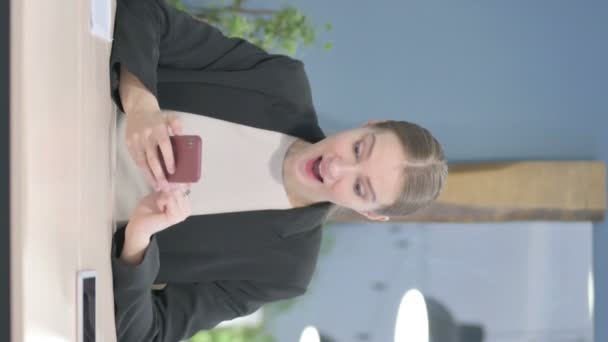 スマートフォンで成功を祝う若いビジネスマンの垂直ビデオ — ストック動画
