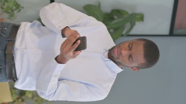 スマートフォンで損失に反応アフリカ系アメリカ人男性の垂直ビデオ — ストック動画