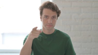 Kendine güvenen genç adam kamerayı işaret ediyor.