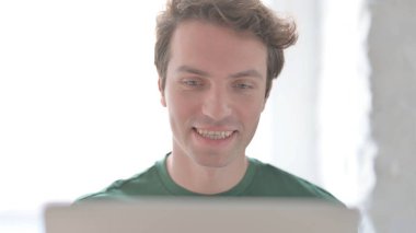 Dizüstü bilgisayarda görüntülü sohbet yapan sıradan genç adamı kapat.