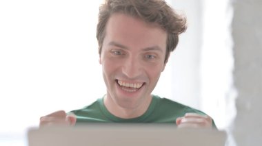 Dizüstü bilgisayarda Başarı Kutlaması Gündelik Genç Adam 'ın Kapanışı