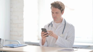 İnternet taraması için Smartphone kullanan Erkek Doktor