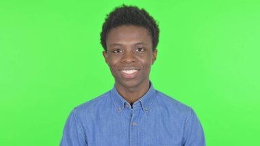 Smiling Casual African Man on Green Background