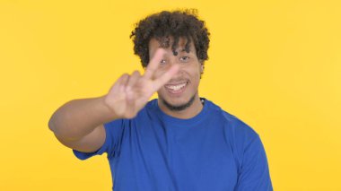 Casual African Man with Victory Sign on Yellow Background