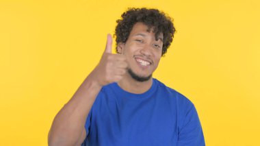Thumbs Up by Casual African Man on Yellow Background