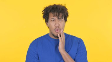 Casual African Man having Toothache on Yellow Background