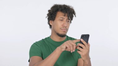 Casual African Man Browsing Smartphone on White Background