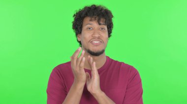 Casual African Man Clapping on Green Background
