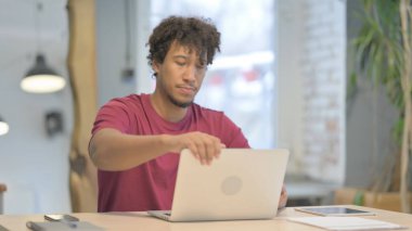 Young African Man Leaving Office after Closing Laptop
