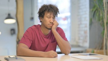Tired Young African Man Sleeping while at Work