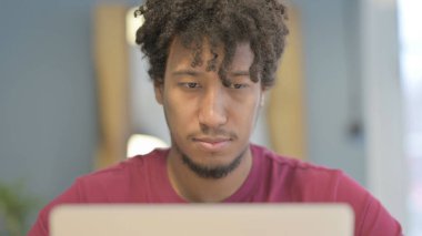 Close Up of Young African Man Typing on Laptop in Office