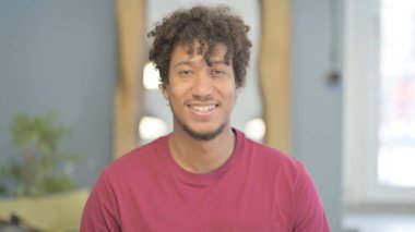 Kameraya gülümseyen Afrikalı bir gencin portresi