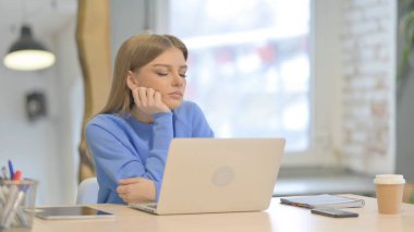 Young Woman Sleeping while Working on Laptop