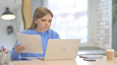 Young Woman Working on Laptop and Documents
