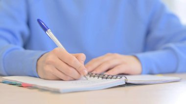 Close up of Young Woman Writing Letter in Office