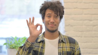 Young African Man with Sign of Victory on White Background