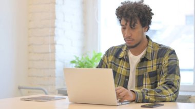 Busy Young African Man Typing on Laptop in Office