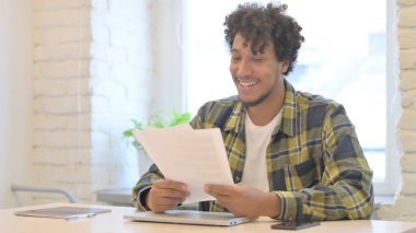 Young African Man Feeling Excited after Reading Documents