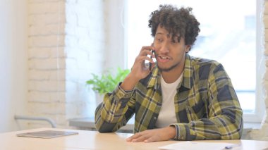 Displeased Young African Man Talking in Anger on Phone